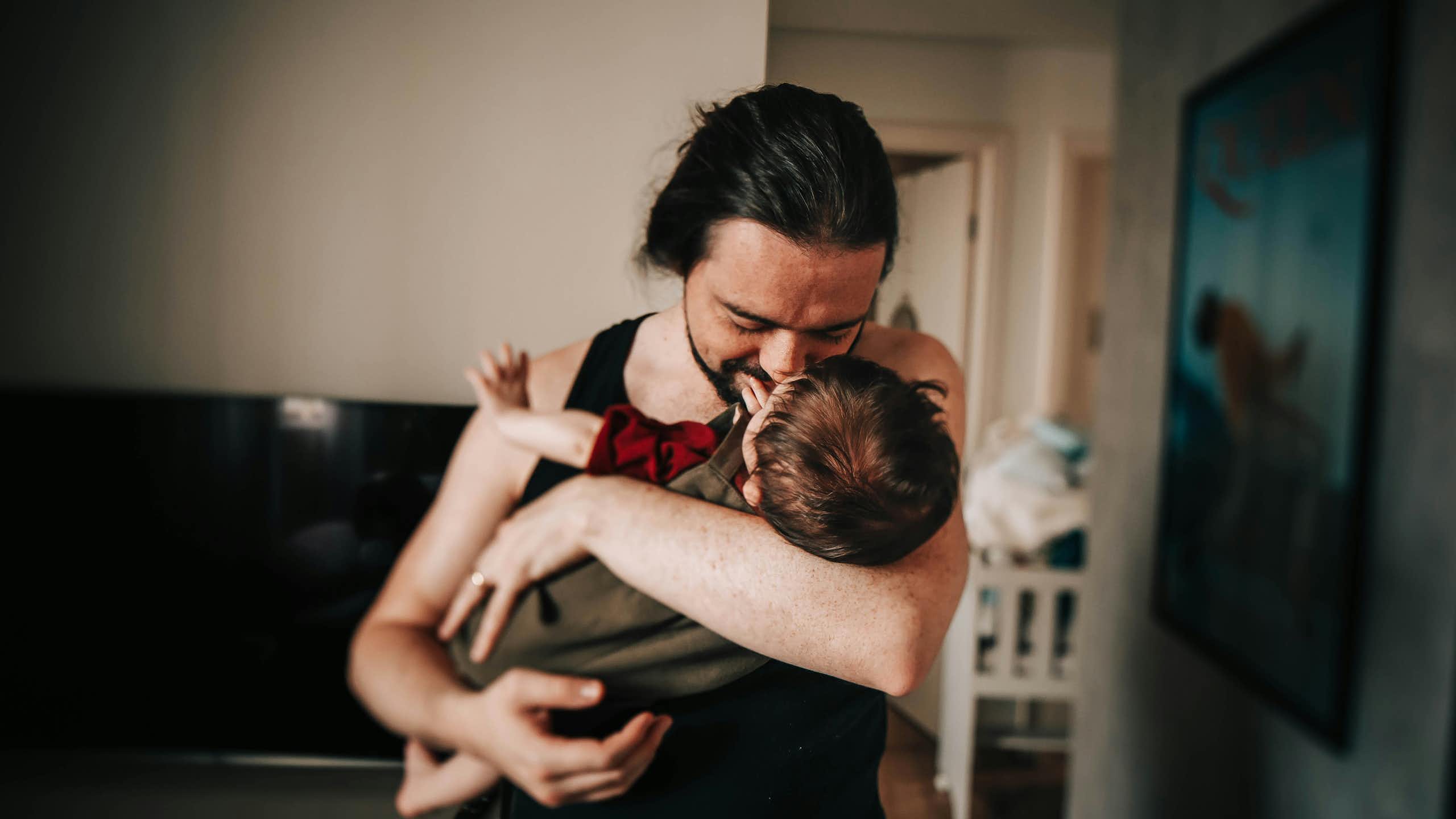 A father cradles a baby. 